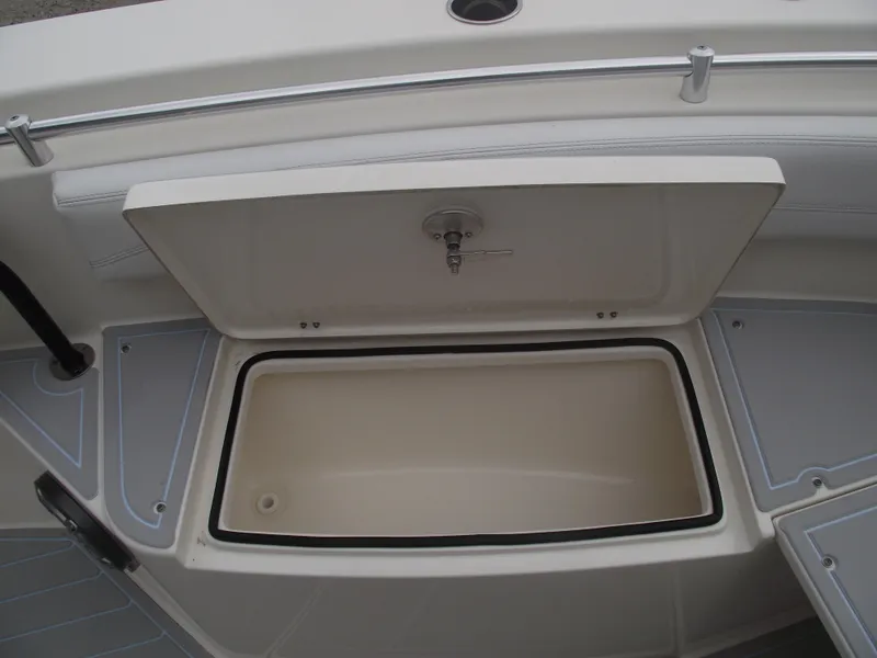 Slide: The Image of 2021 Cobia 301 Center Console storage compartment with open lid, showcasing interior space. - 11