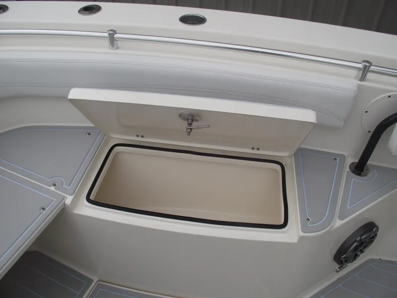 Slide: The Image of 2021 Cobia 301 Center Console boat storage compartment open, showcasing interior space. - 16