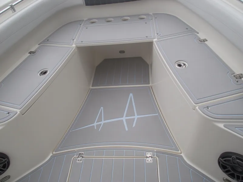 Slide: The Image of 2021 Cobia 301 Center Console boat interior with gray deck and storage compartments. - 17