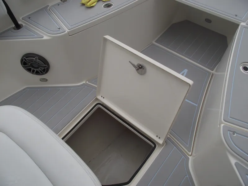 Slide: The Image of 2021 Cobia 301 Center Console boat with open storage compartment and sleek interior design. - 24