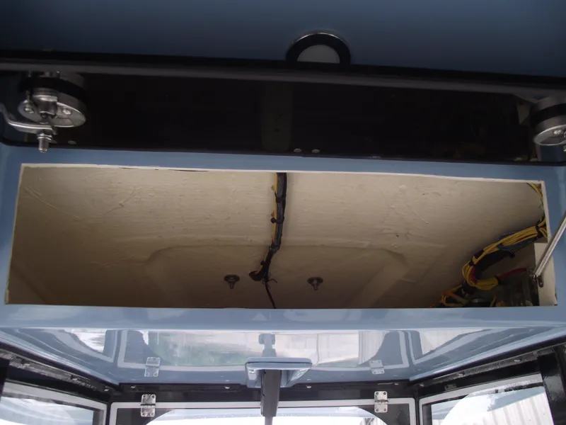 Slide: The Image of 2021 Cobia 301 Center Console storage compartment with wiring visible. - 38