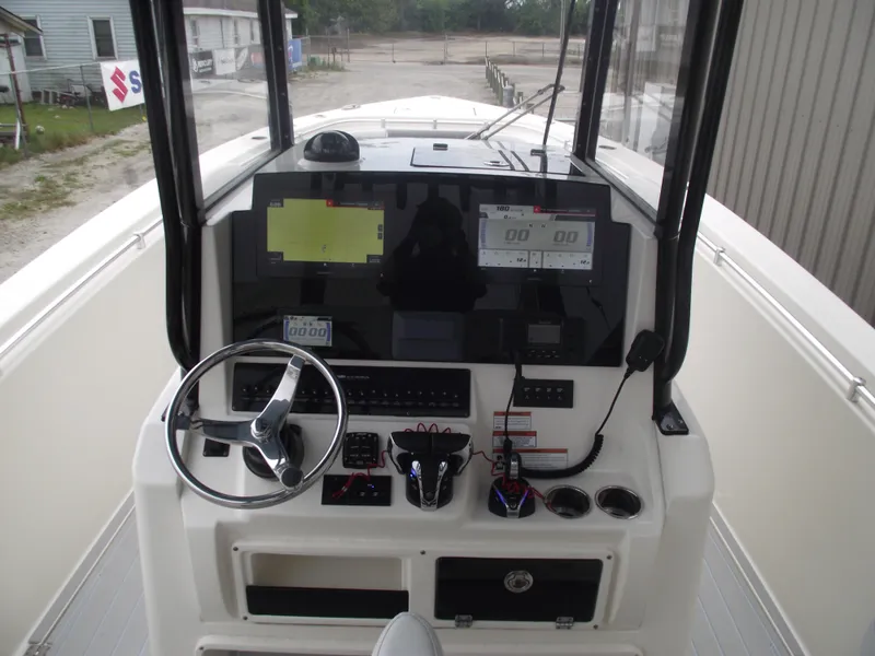 Slide: The Image of 2021 Cobia 301 Center Console boat dashboard with steering wheel and electronic displays. - 41