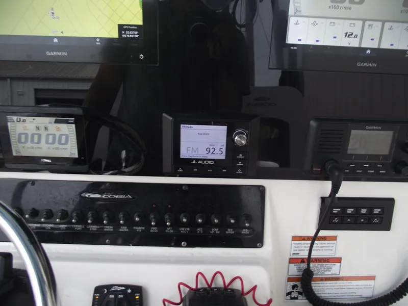 Slide: The Image of 2021 Cobia 301 Center Console dashboard with Garmin displays and JL Audio system. - 44