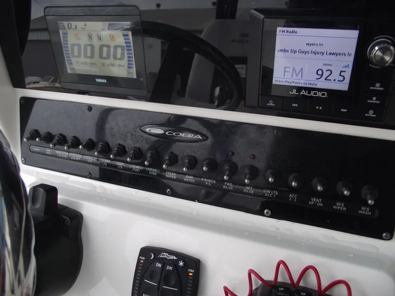 Slide: The Image of Control panel of a 2021 Cobia 301 Center Console boat with electronic displays. - 45