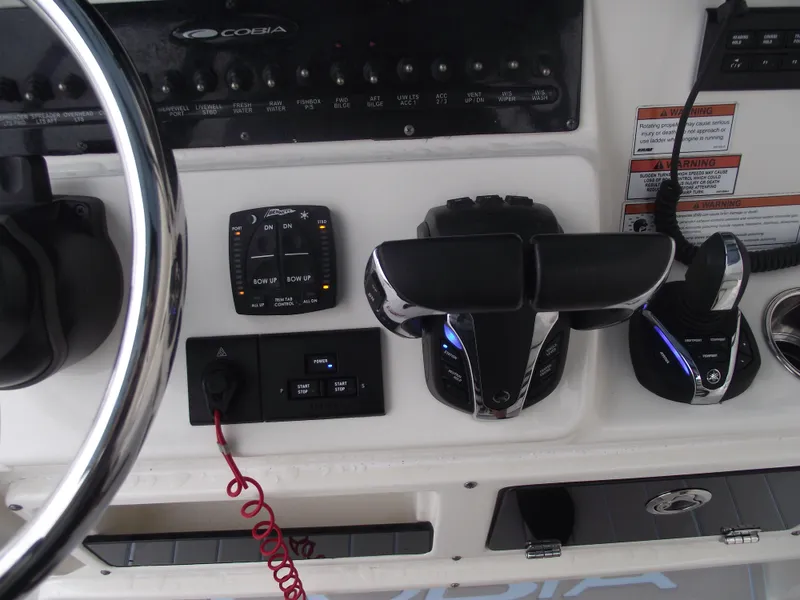 Slide: The Image of 2021 Cobia 301 Center Console dashboard with steering wheel and control panel. - 46