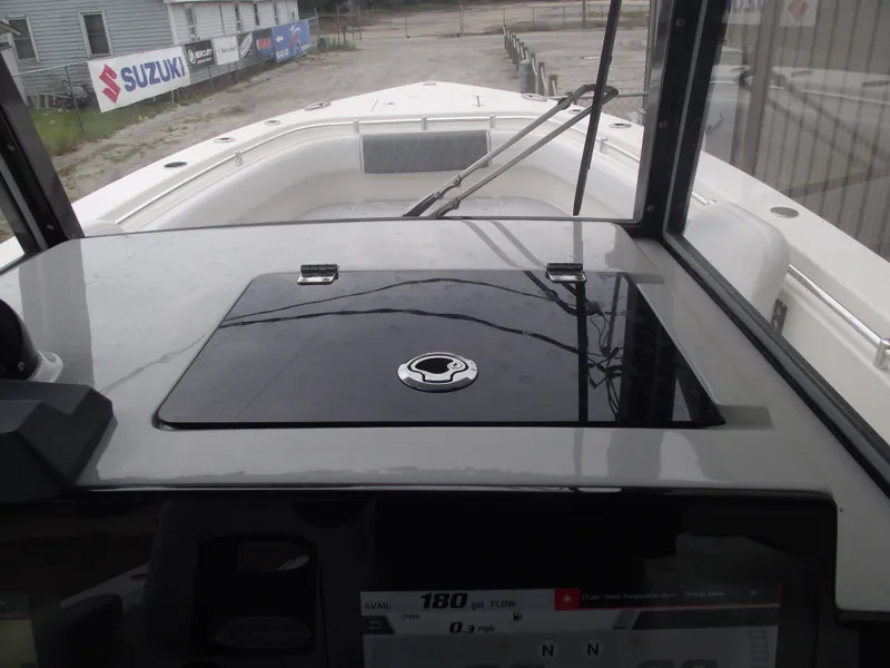 Slide: The Image of 2021 Cobia 301 Center Console boat dashboard with navigation controls and windshield view. - 49