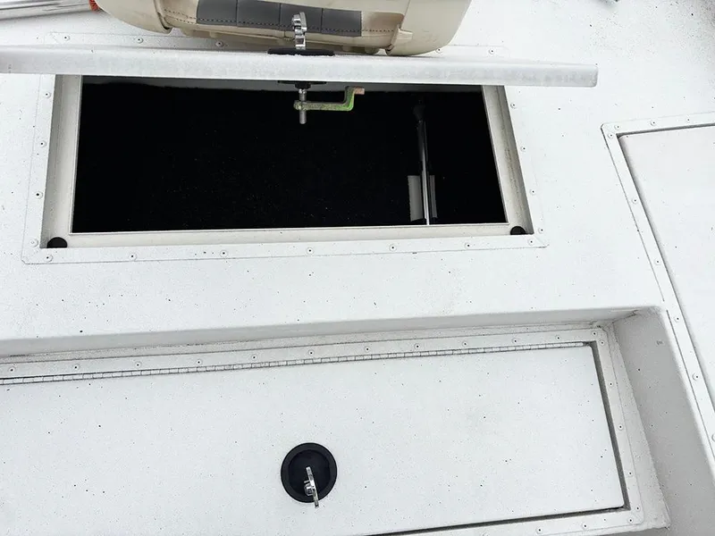 Slide: The Image of 2023 G3 Bay 18 GX boat storage compartments, open and closed, on a white deck. - 14