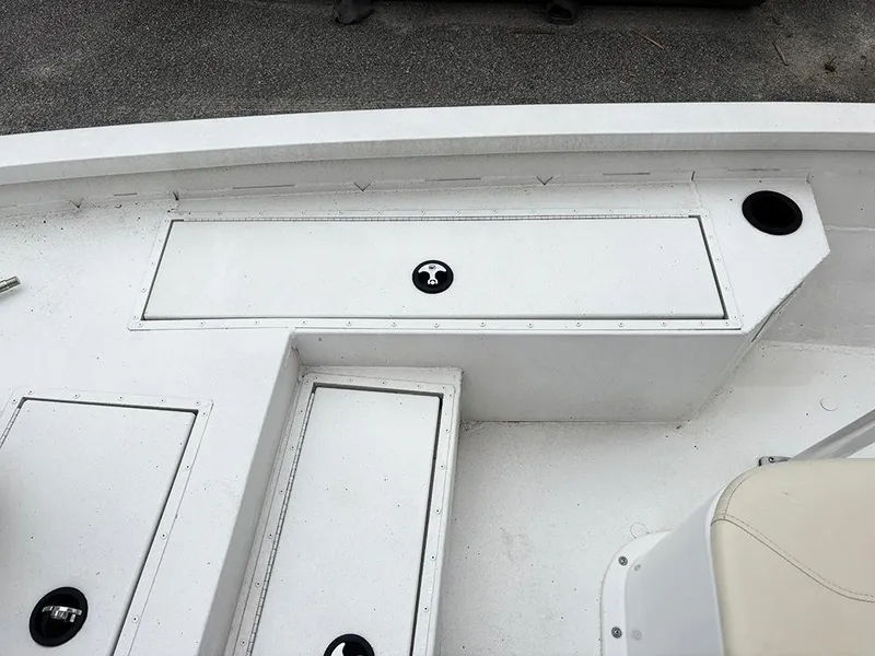 Slide: The Image of 2023 G3 Bay 18 GX boat deck with storage compartments and cup holder. - 16