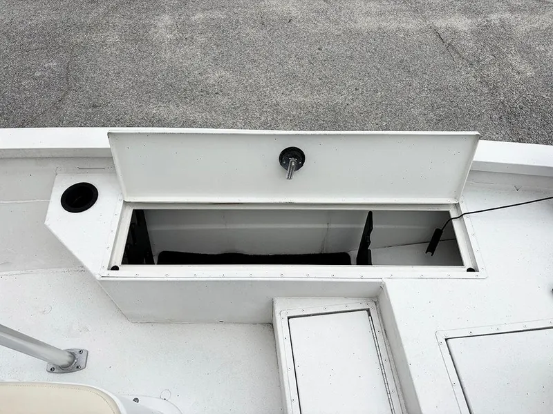Slide: The Image of 2023 G3 Bay 18 GX boat storage compartment, open lid, white interior, on a gray surface. - 19