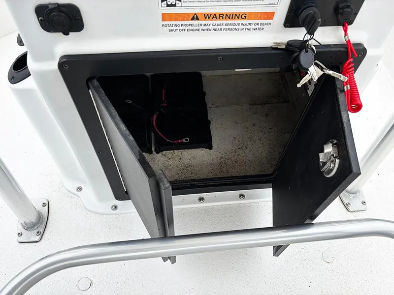 Slide: The Image of Open storage compartment on 2023 G3 Bay 18 GX boat with keys and warning label visible. - 23