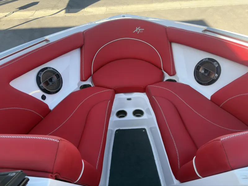 Slide: The Image of 2018 MasterCraft XT23 boat interior with red seating and built-in speakers. - 11