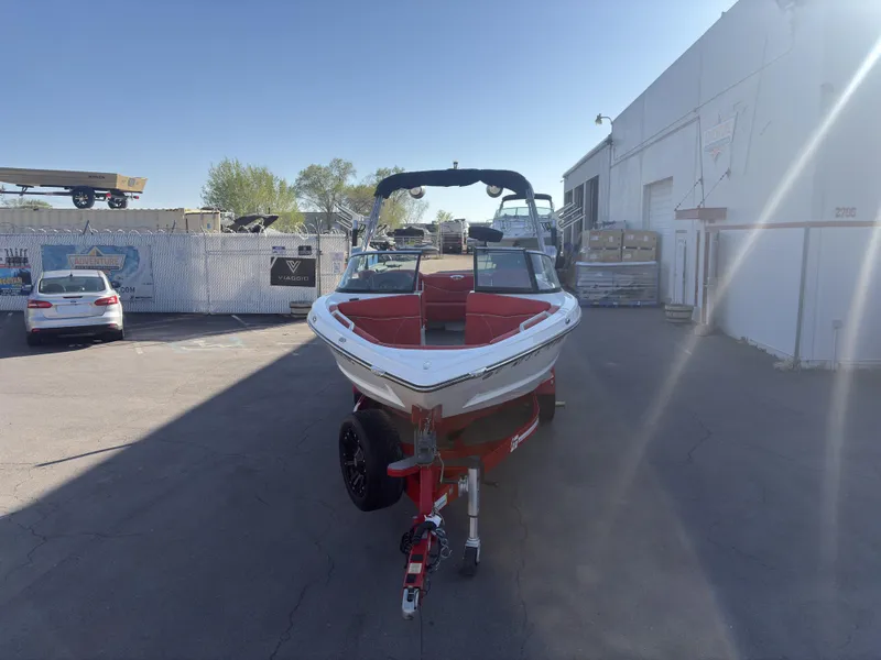 Slide: The Image of 2018 MasterCraft XT23 boat on trailer in industrial lot. - 2