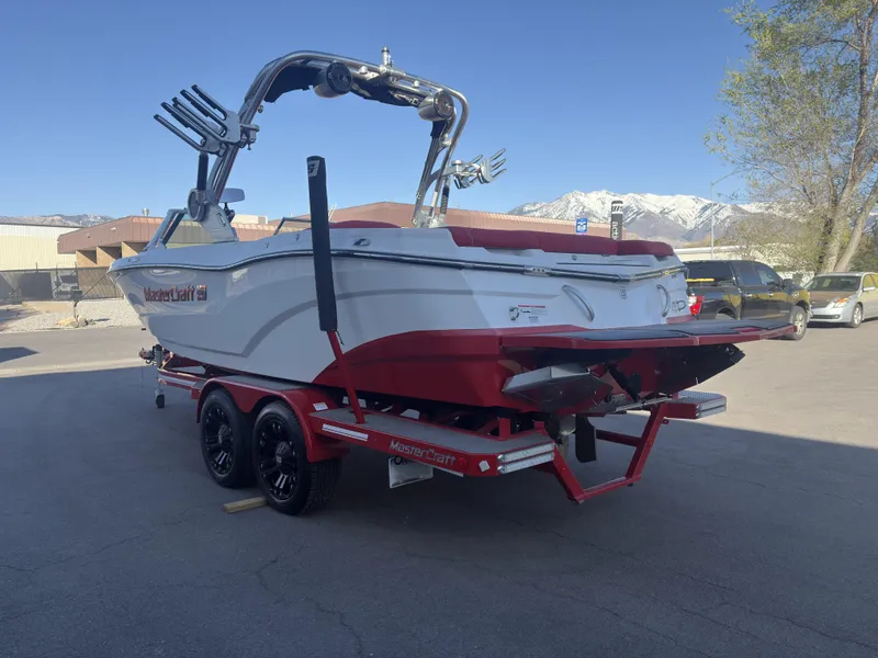 Slide: The Image of 2018 MasterCraft XT23 boat on trailer, red and white, parked outdoors. - 5