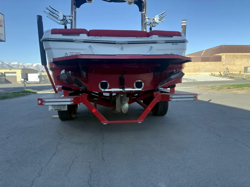 Slide: The Image of 2018 MasterCraft XT23 boat rear view with red and white design on a trailer. - 6