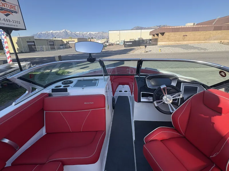 Slide: The Image of 2018 MasterCraft XT23 boat interior with red seating and modern dashboard. - 7