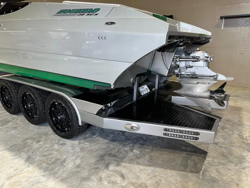 Slide: The Image of 2013 Howard 28 SCS boat on trailer, featuring sleek design and triple-axle wheels. - 14