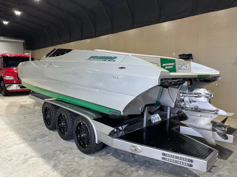 Slide: The Image of 2013 Howard 28 SCS speedboat on a triple-axle trailer in a garage setting. - 4