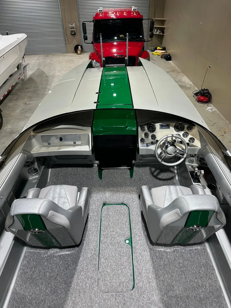 Slide: The Image of 2013 Howard 28 SCS boat interior with green accents, parked in a garage. - 8