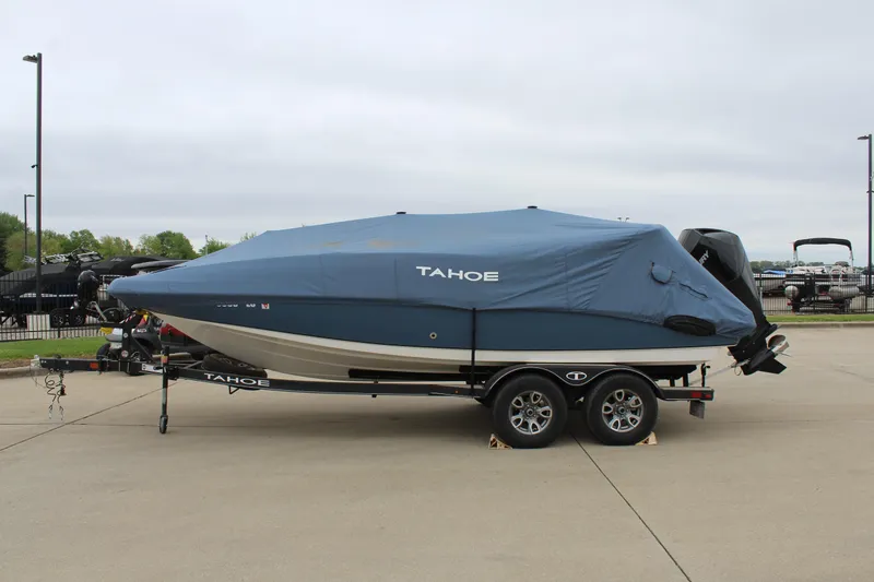 Slide: The Image of 2022 Tahoe 2150 boat with cover on trailer, parked outdoors. - 12