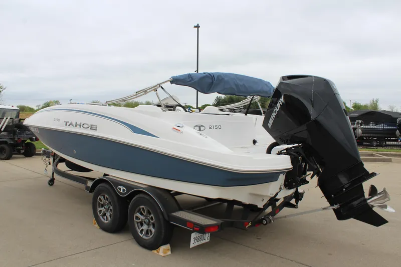 Slide: The Image of 2022 Tahoe 2150 boat on trailer, featuring a blue and white design with an outboard motor. - 5