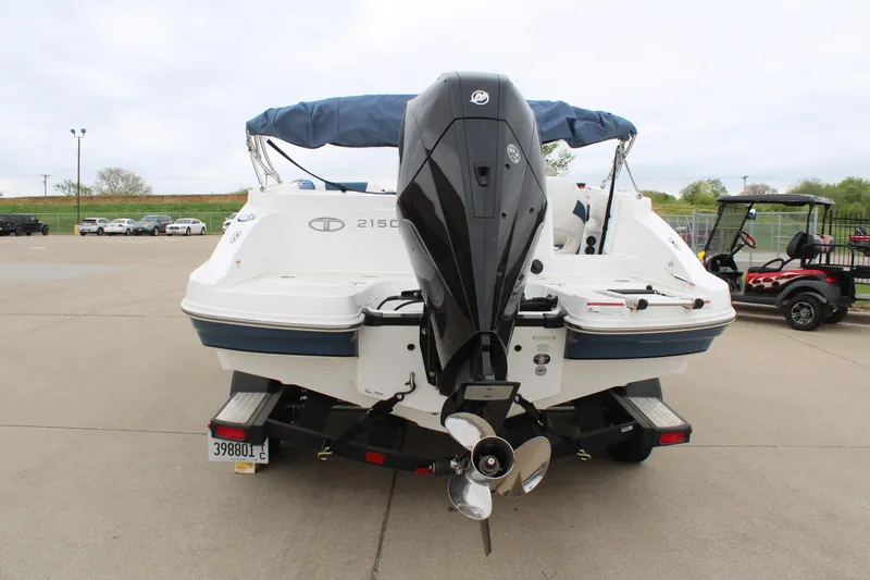 Slide: The Image of 2022 Tahoe 2150 boat with outboard motor, parked on a trailer in a lot. - 6