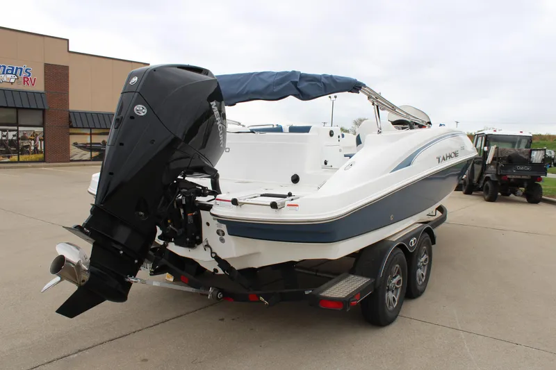 Slide: The Image of 2022 Tahoe 2150 boat on trailer with outboard motor, parked outside dealership. - 7