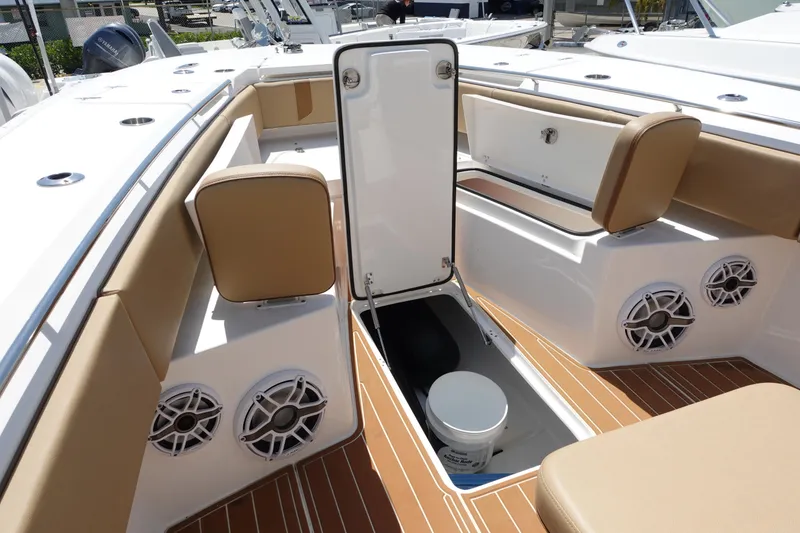 Slide: The Image of 2022 Cape Horn 34 XS boat interior with storage hatch, tan seating, and marine speakers. - 25