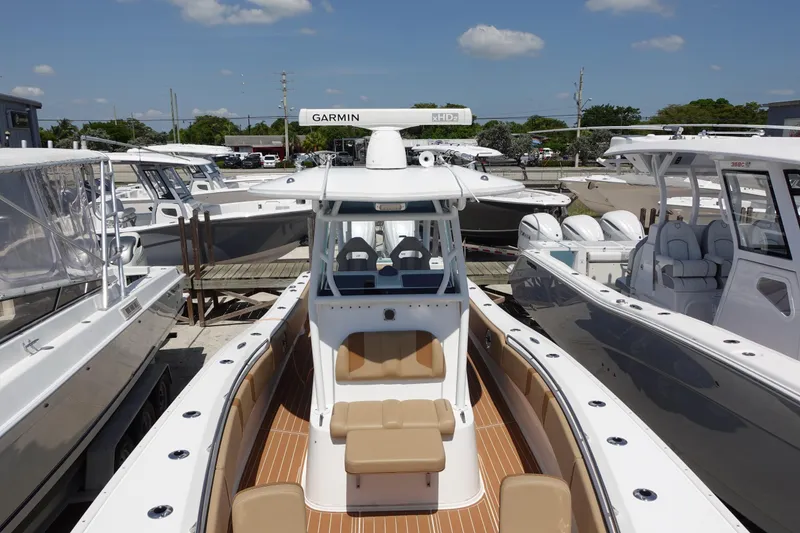 Slide: The Image of 2022 Cape Horn 34 XS boat with tan seating, docked among other boats under a clear sky. - 31