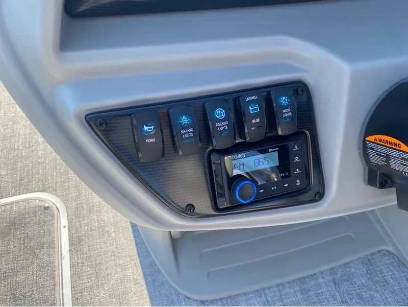 Slide: The Image of Control panel of 2025 Trifecta 24 UL LE boat with switches and radio display. - 40