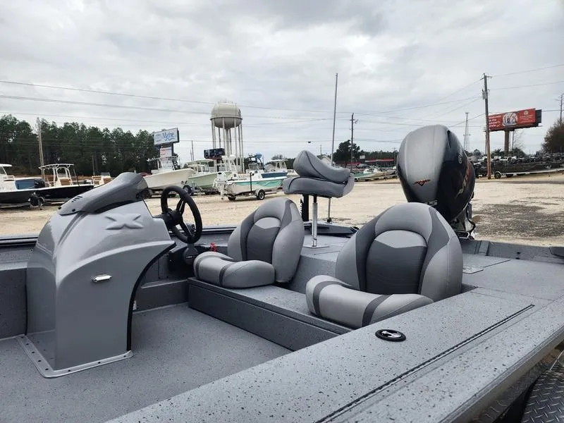 Slide: The Image of 2024 Xpress XP200 Catfish boat with gray interior and seating, parked outdoors. - 10