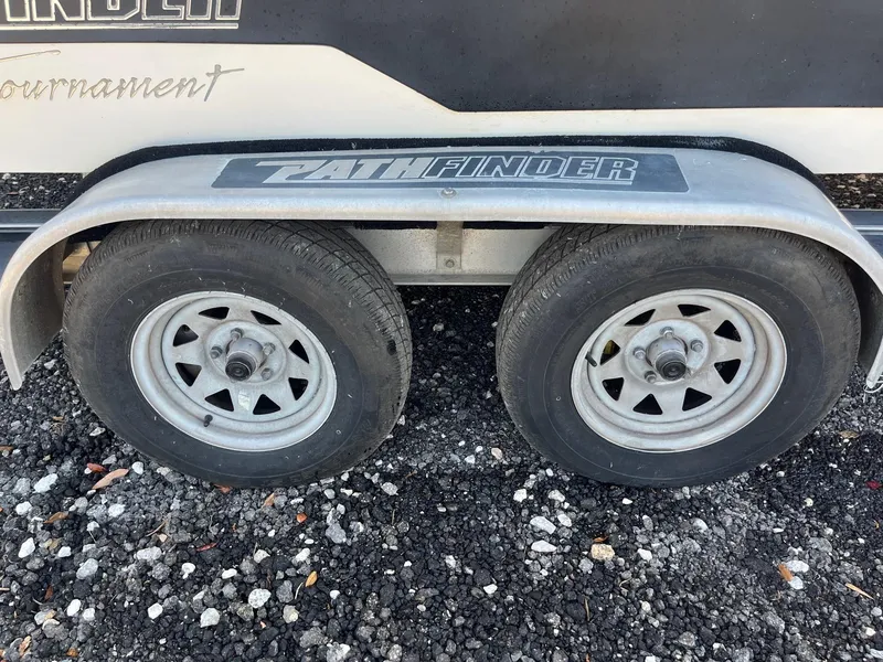 Slide: The Image of Trailer wheels of a 2008 Pathfinder 2200 Tournament Edition on gravel. - 6