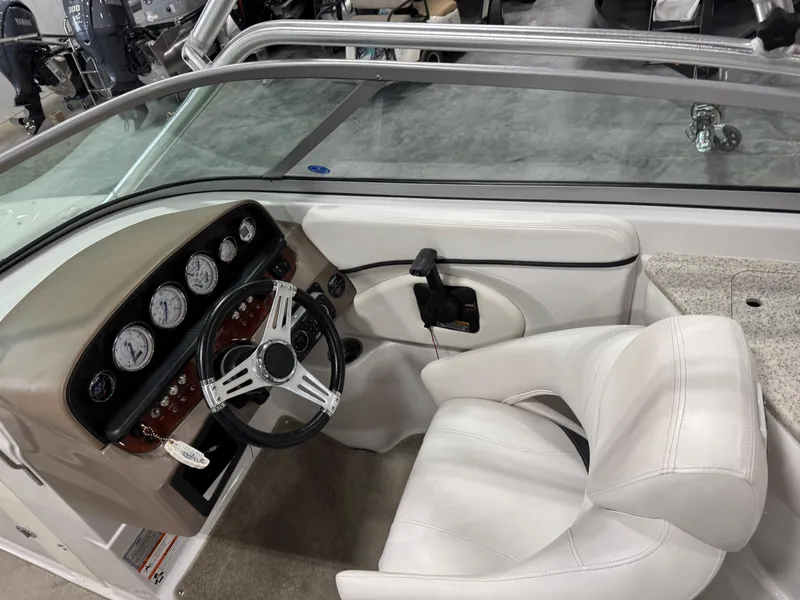 Slide: The Image of 2009 Four Winns H-260 boat interior with white seating and dashboard controls. - 10