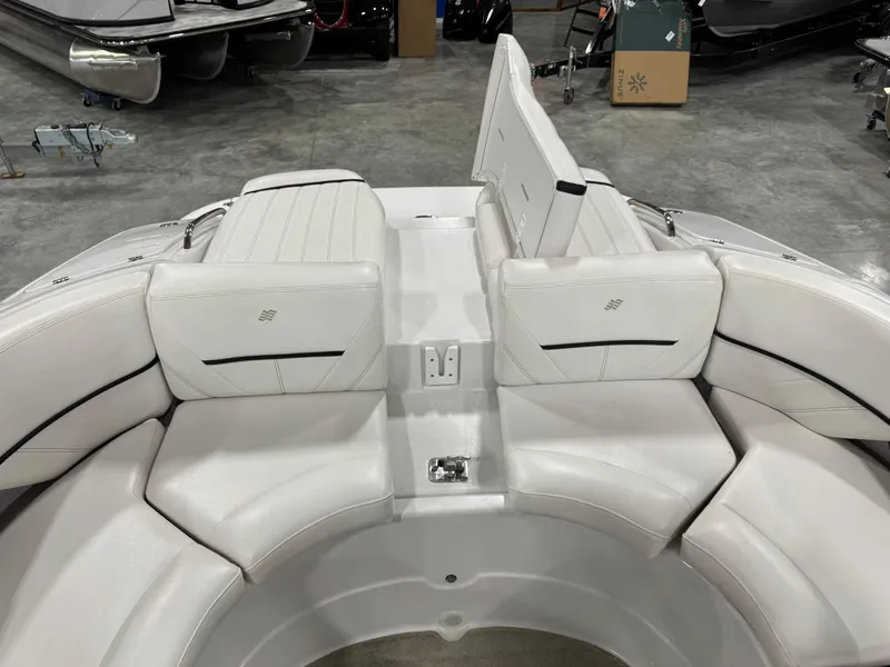 Slide: The Image of 2009 Four Winns H-260 boat interior with white cushioned seating in a showroom. - 11