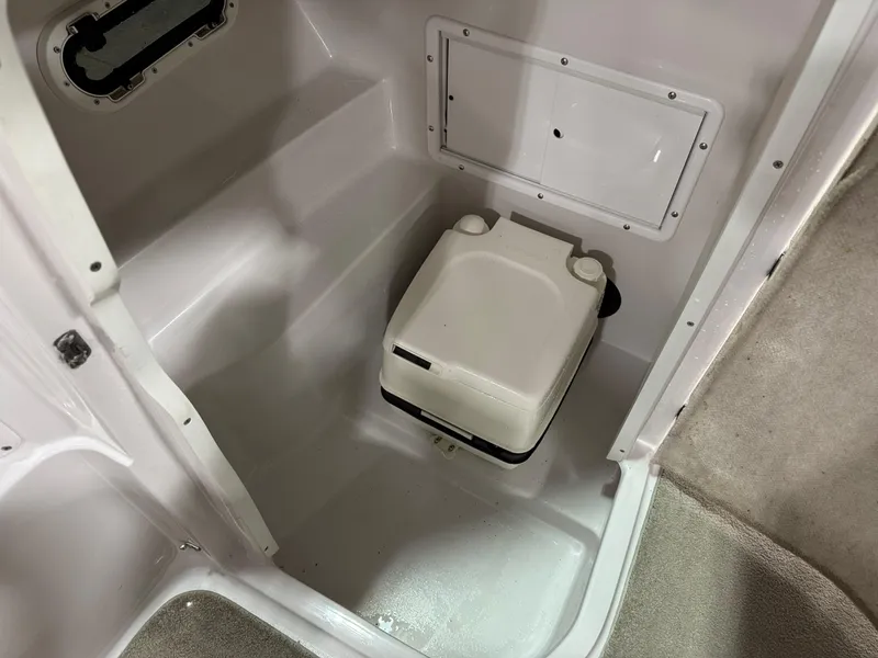 Slide: The Image of 2009 Four Winns H-260 boat interior with compact portable toilet. - 13