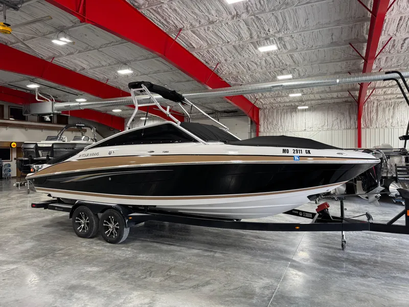 Slide: The Image of 2009 Four Winns H-260 boat in a showroom, black and white exterior, on a trailer. - 14
