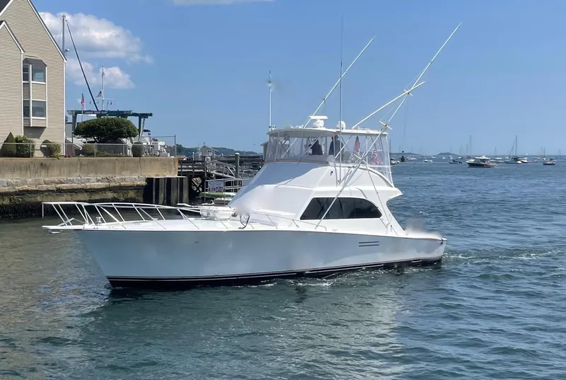 Slide: The Image of White 1997 Post 50 Convertible yacht cruising near a marina on a sunny day. - 0