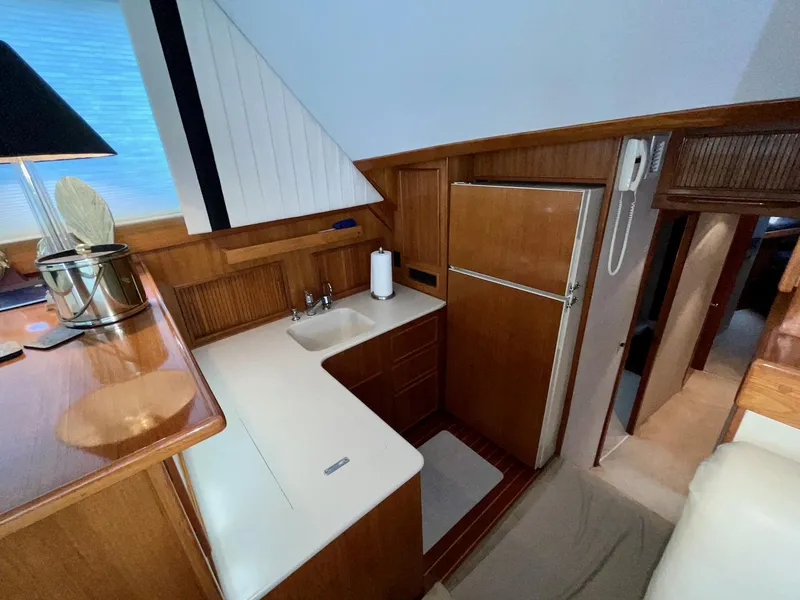 Slide: The Image of 1997 Post 50 Convertible yacht interior with compact kitchen, wooden cabinetry, and modern appliances. - 17
