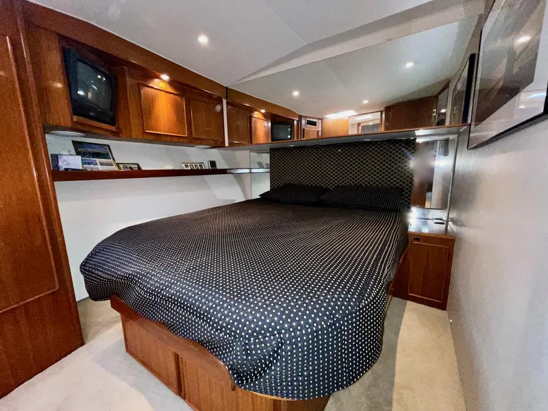 Slide: The Image of Luxurious bedroom interior of a 1997 Post 50 Convertible yacht with wood cabinetry. - 18