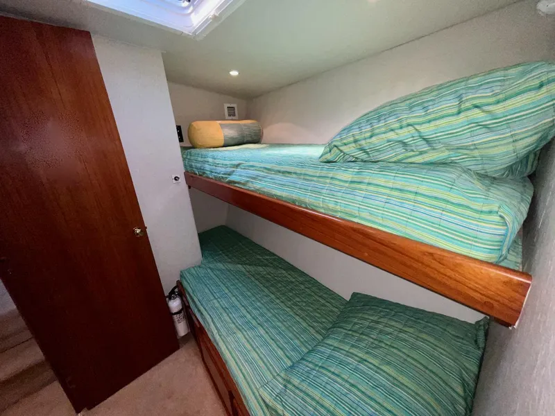 Slide: The Image of Bunk beds in a 1997 Post 50 Convertible yacht cabin with striped bedding. - 2