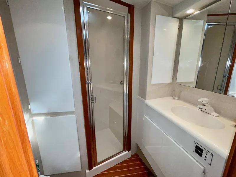 Slide: The Image of 1997 Post 50 Convertible yacht bathroom with shower, sink, and wooden accents. - 21