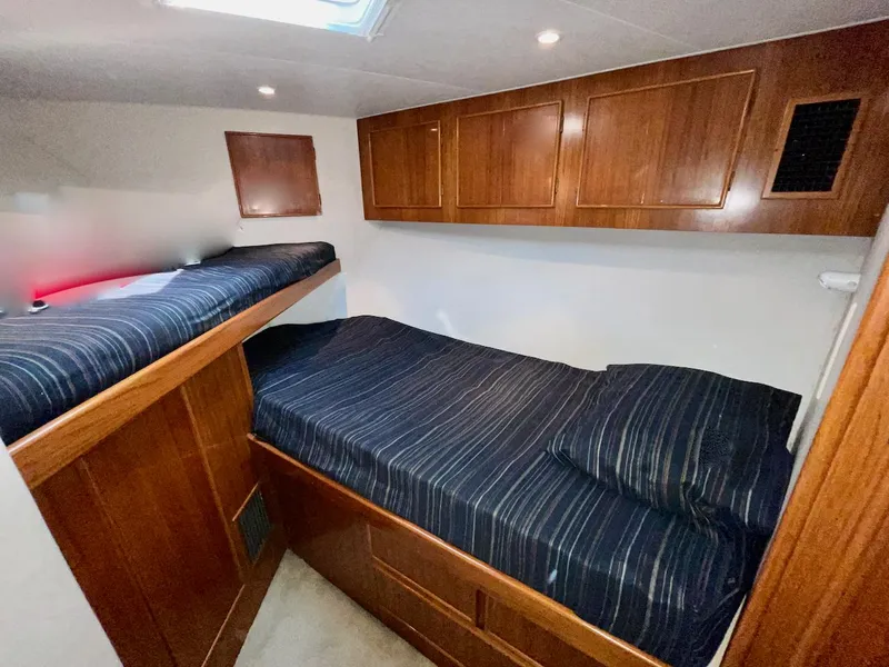 Slide: The Image of Cozy cabin interior of a 1997 Post 50 Convertible yacht with wooden cabinets and twin beds. - 23