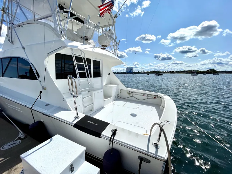 Slide: The Image of 1997 Post 50 Convertible yacht docked by the water under a sunny sky. - 26