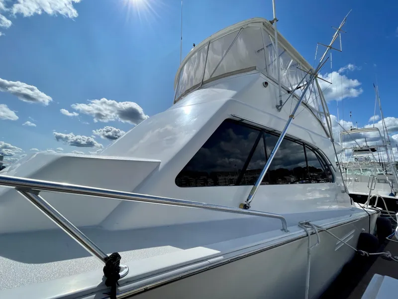 Slide: The Image of 1997 Post 50 Convertible yacht under a bright blue sky with clouds. - 27