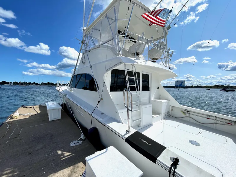 Slide: The Image of 1997 Post 50 Convertible yacht docked by the water under a clear blue sky. - 28