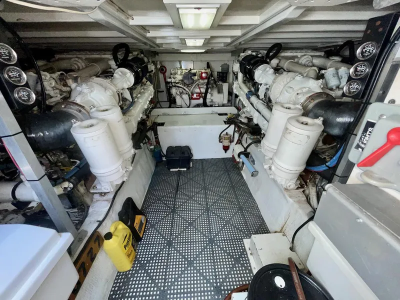 Slide: The Image of Engine room of a 1997 Post 50 Convertible yacht, featuring dual engines and mechanical equipment. - 37
