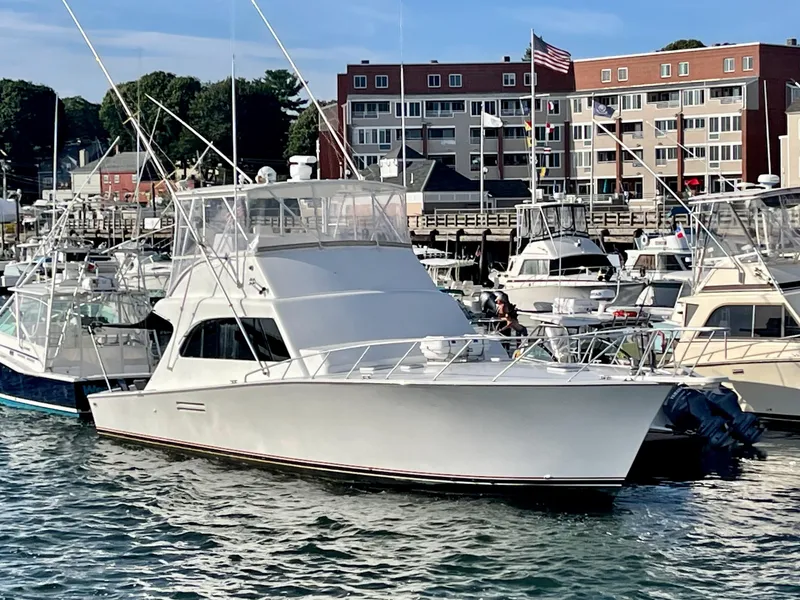 Slide: The Image of 1997 Post 50 Convertible yacht docked in a marina with buildings in the background. - 42