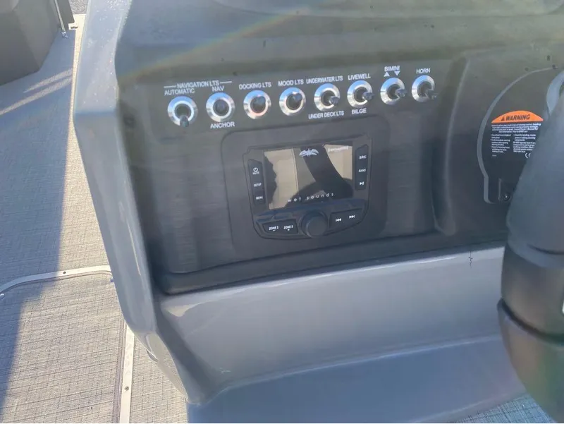 Slide: The Image of Control panel of 2025 Trifecta C Series 24RFC boat with various switches and display. - 10