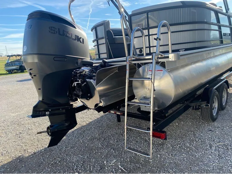 Slide: The Image of 2025 Trifecta C Series 24RFC pontoon boat with Suzuki outboard motor on trailer. - 4