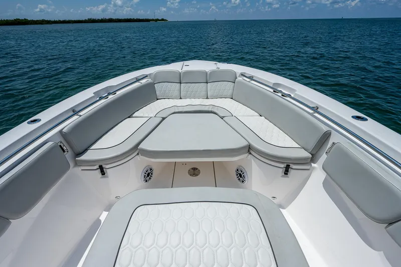 Slide: The Image of 2022 Sea Fox 288 Commander boat interior with cushioned seating, on calm ocean waters. - 12
