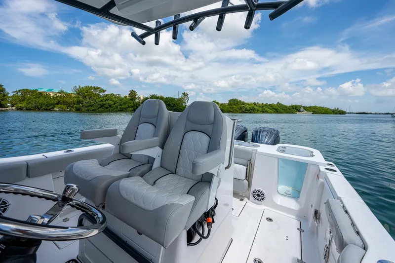 Slide: The Image of 2022 Sea Fox 288 Commander boat interior with plush seating, steering wheel, and scenic water view. - 23
